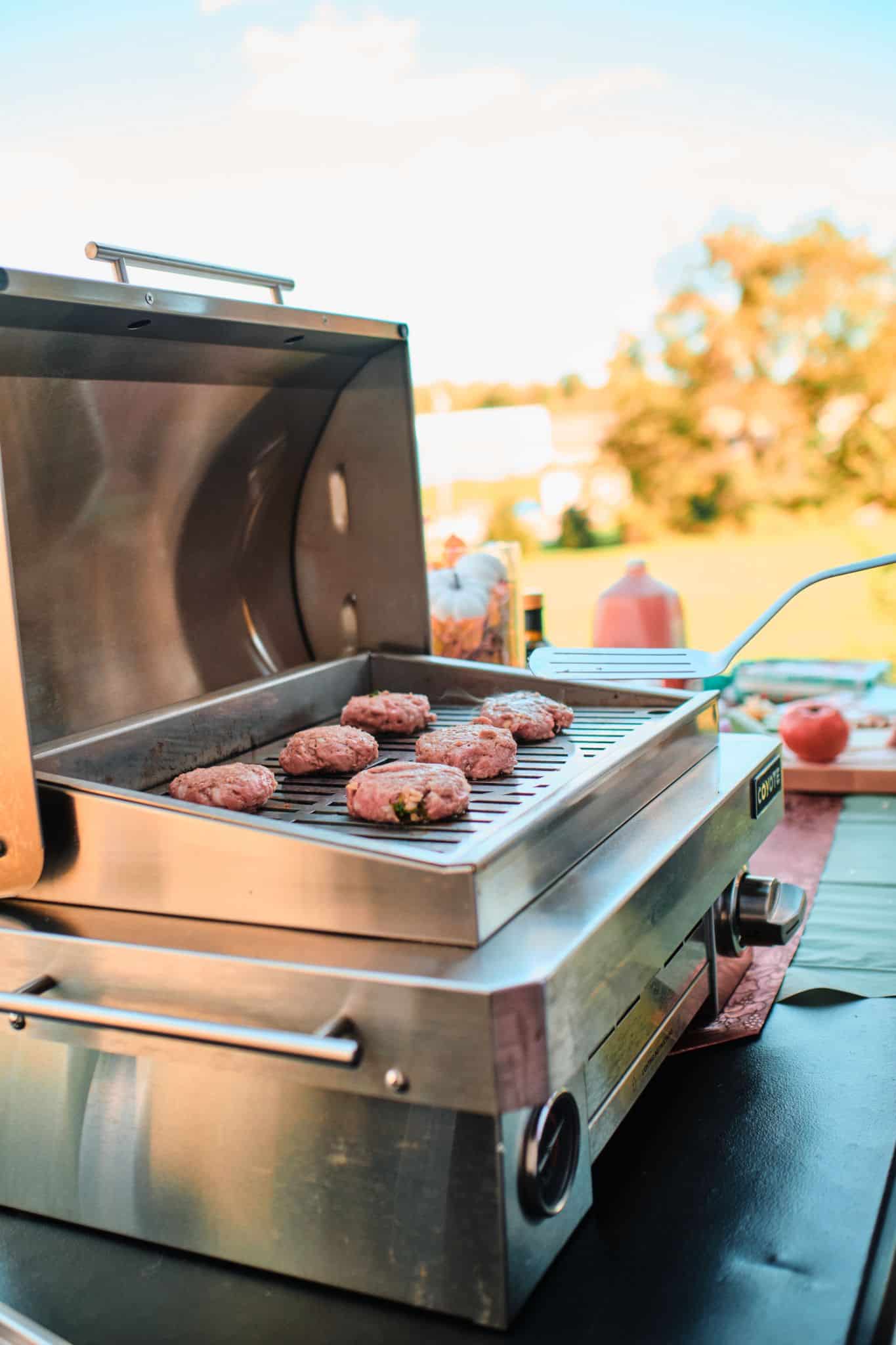 Burgers Grilling on Coyote Outdoor Living Portable Grill